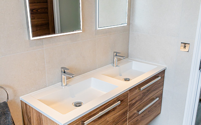 Stylish wood-effect vanity unit with dual sinks suited for contemporary bathrooms.