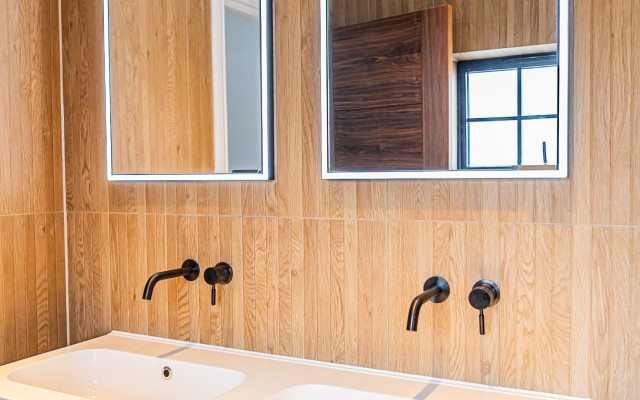 Elegant twin-vanity with wall taps and mirrored lighting