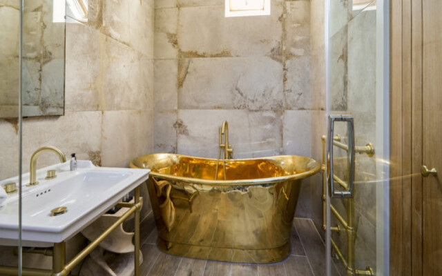 Luxurious golden bathroom design featuring a stunning gold tub.