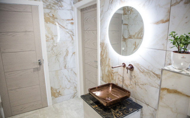 Round mirror copper basin in a luxurious bathroom setting.