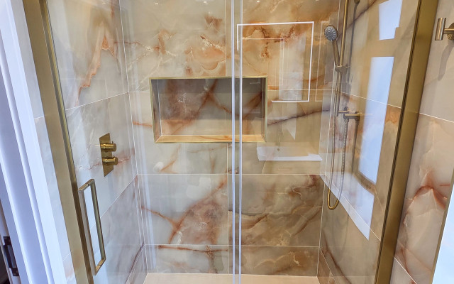 Experience luxury in your shower room with our stunning shower enclosure featuring elegant gold detailing and sophisticated marble tiles.