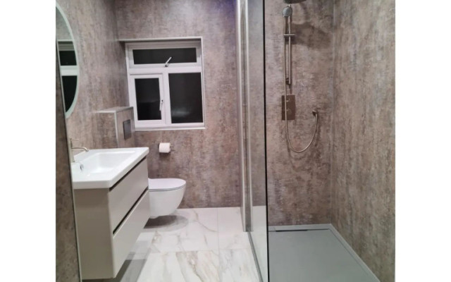 Experience luxury with this stunning salmon-pink walk-in shower, featuring a modern design and sleek functionality.