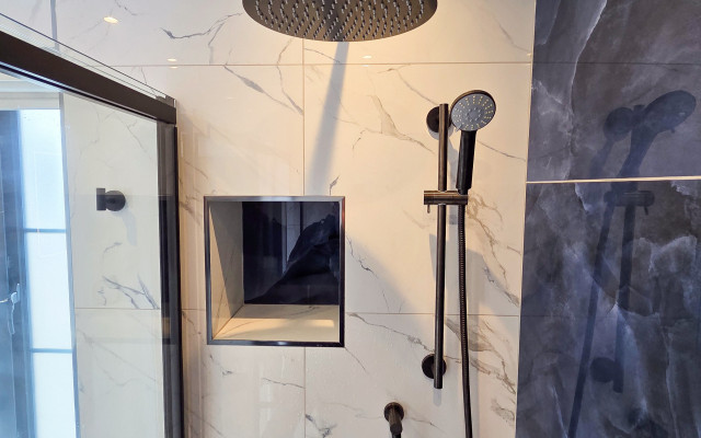 Stylish black shower fixtures set against elegant blue and white tiles.